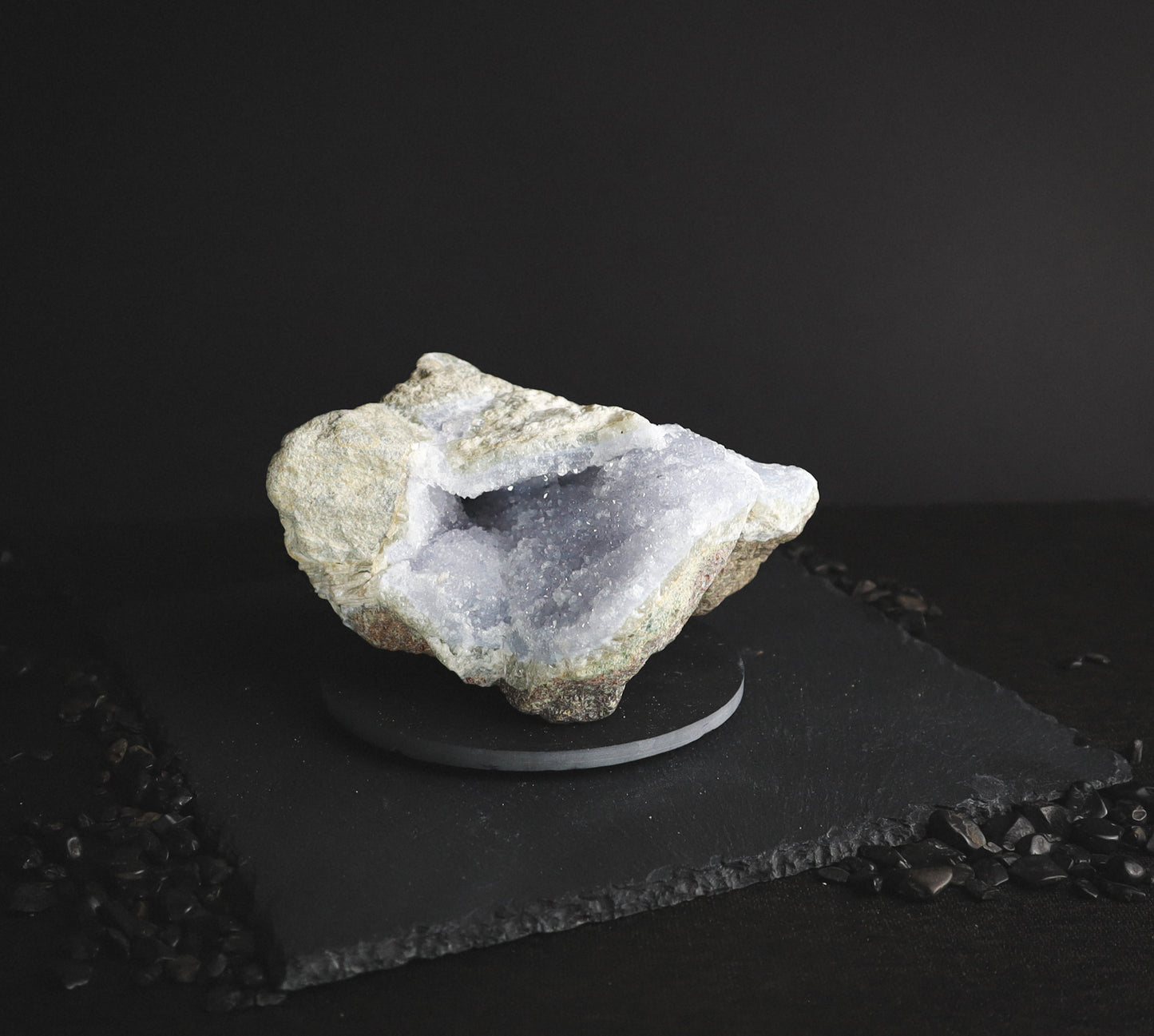 Light blue raw mineral on a dark table.