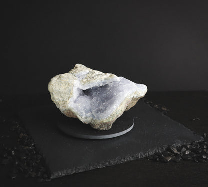 Light blue raw mineral on a dark table.