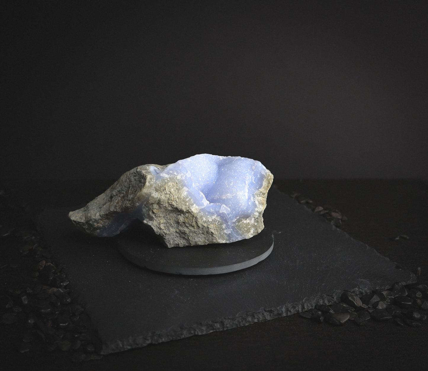 Gentle blue-coloured crystal on a dark table.