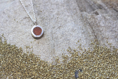 round silver pendant with Sahara desert sand inlay