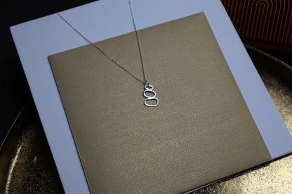 silver necklace with a pendant that has three non-symetrical circular shapes stacked on top of each other