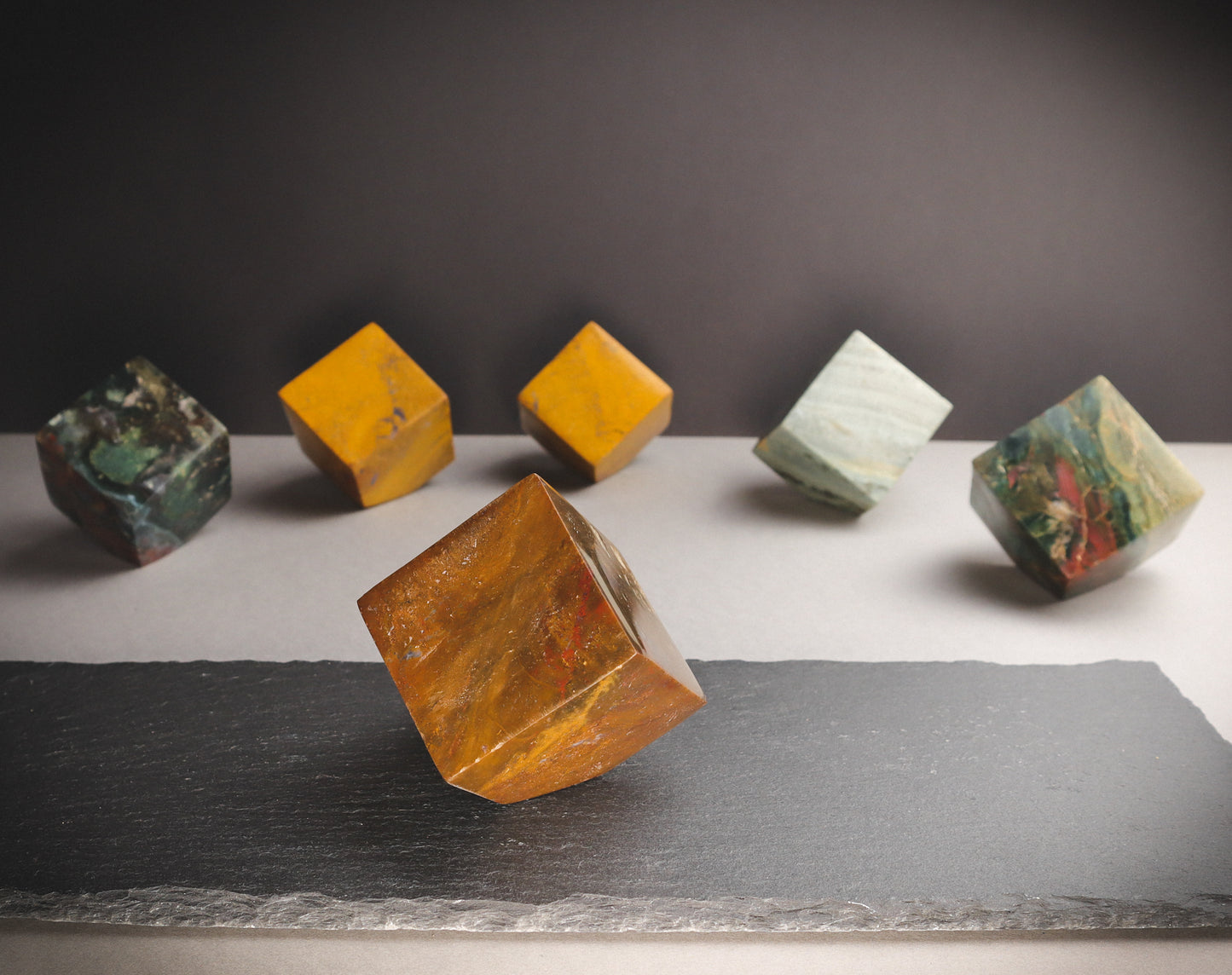 Orange crystal cube on a dark plate.