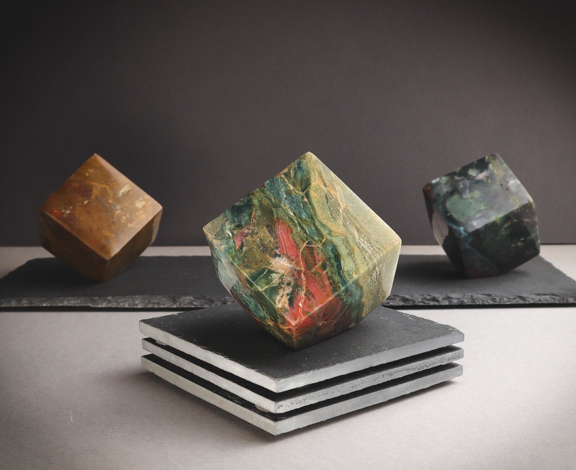 Multi-coloured tilted cubes on a pedestal.