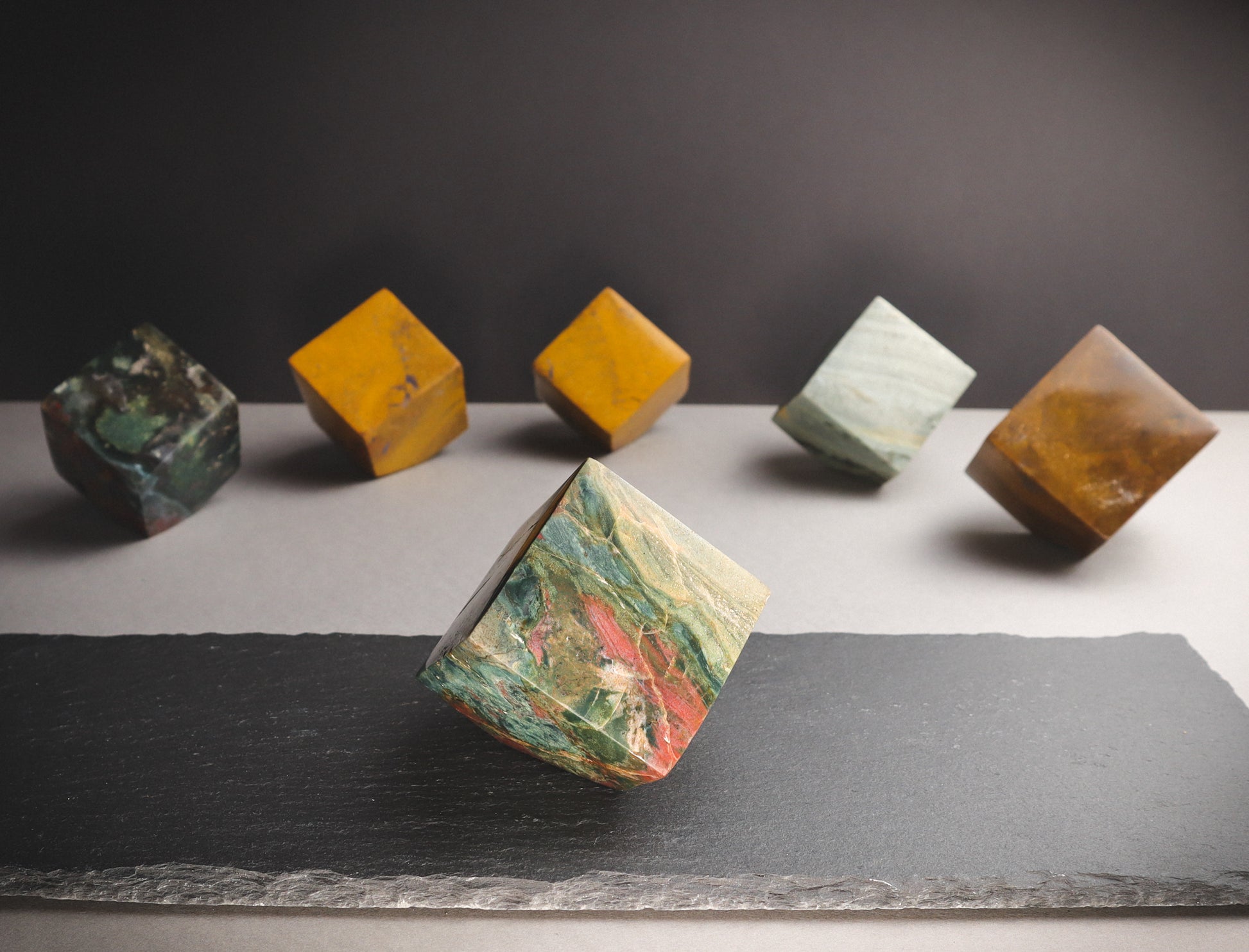 Colourful cube tilting on a dark plate.