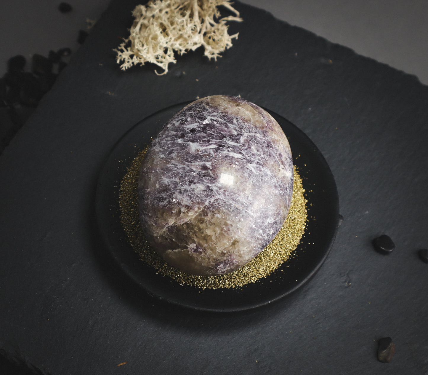 Violet-coloured crystal on a black plate.