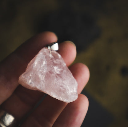 Pink mineral pendant in a hand. je na ROŽEVEC (Surovi) - Obesek  je kamen čiste brezpogojne ljubezni.