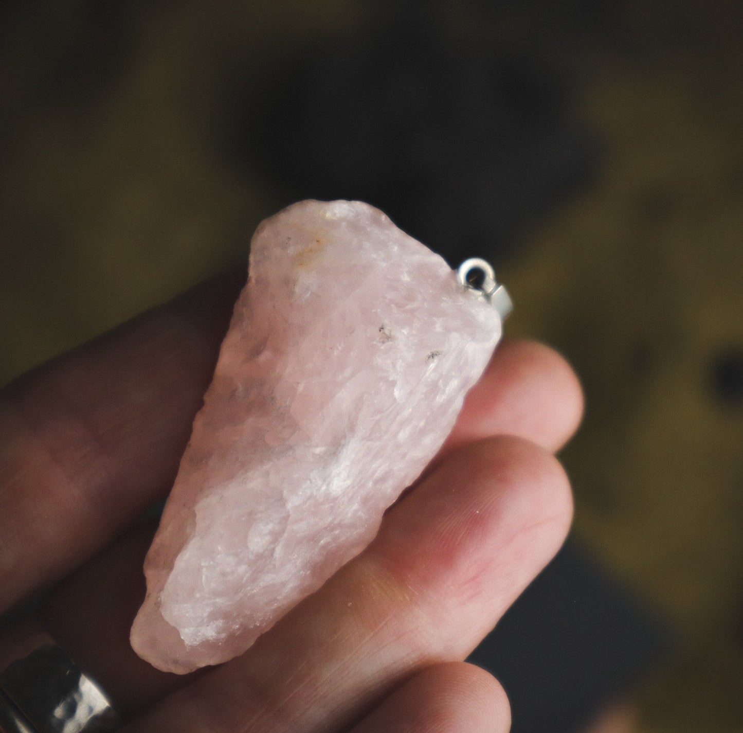 Raw pink crystal pendant in a hand. je na ROŽEVEC (Surovi) - Obesek  je kamen čiste brezpogojne ljubezni.