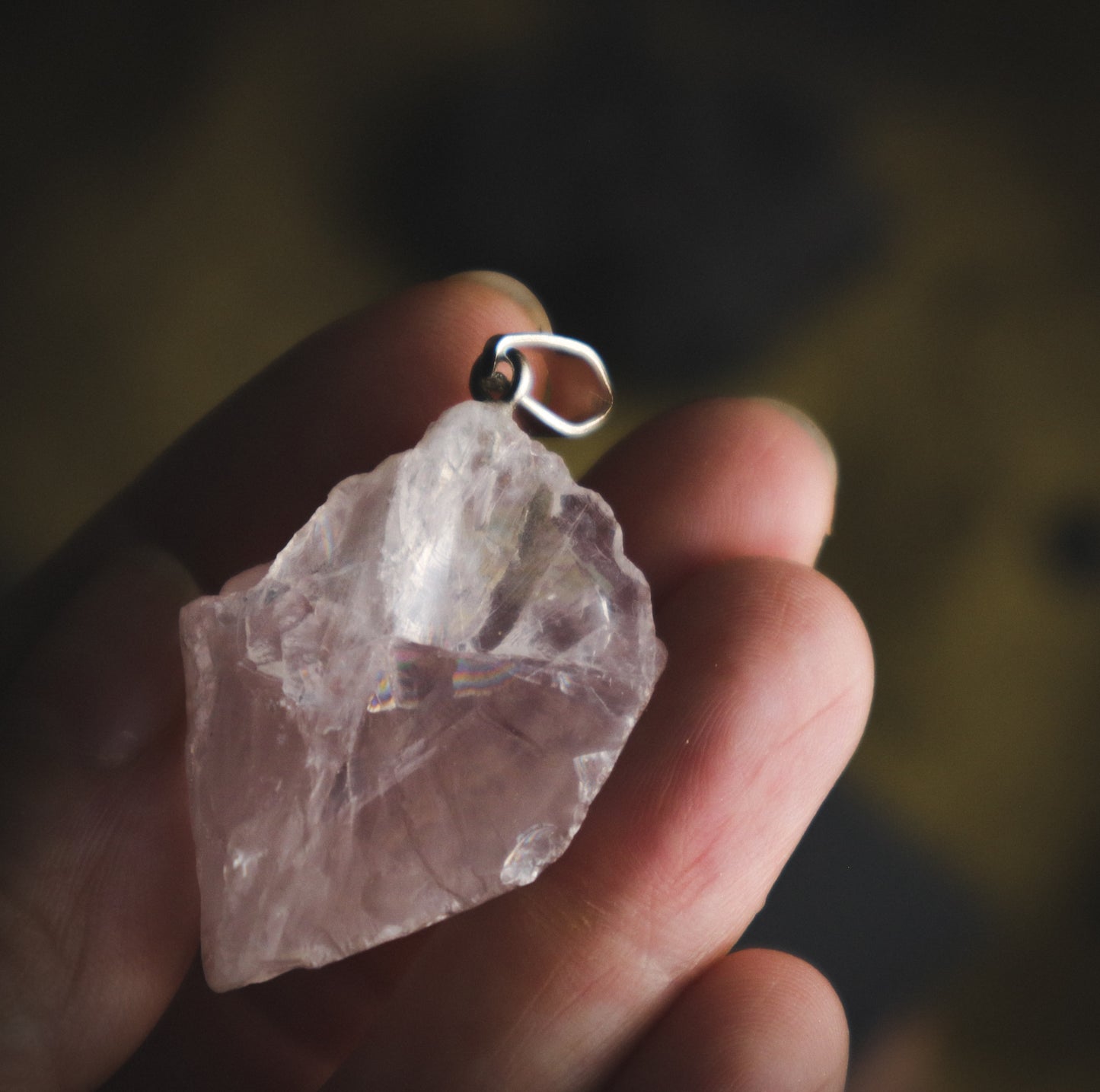 Transparent rose quartz pendant in a hand. je na ROŽEVEC (Surovi) - Obesek  je kamen čiste brezpogojne ljubezni.