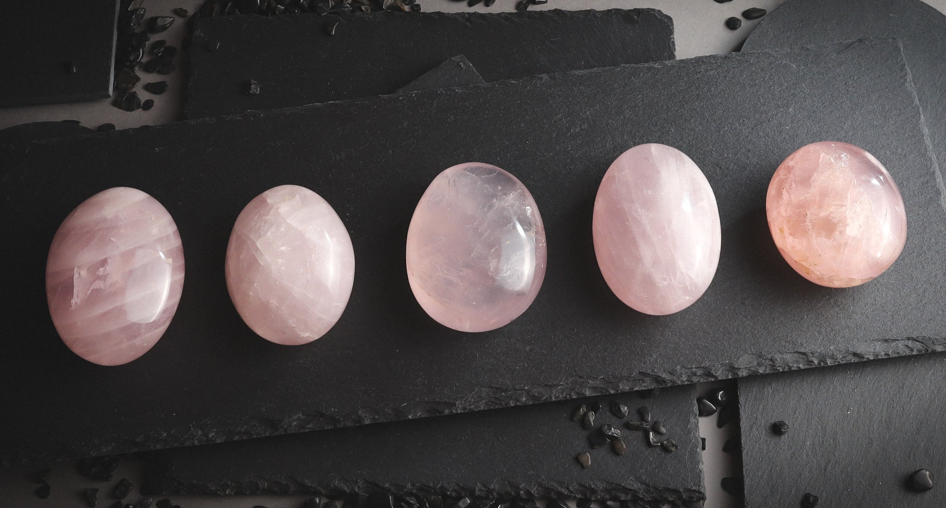 A set of pink palmstones on a black plate.