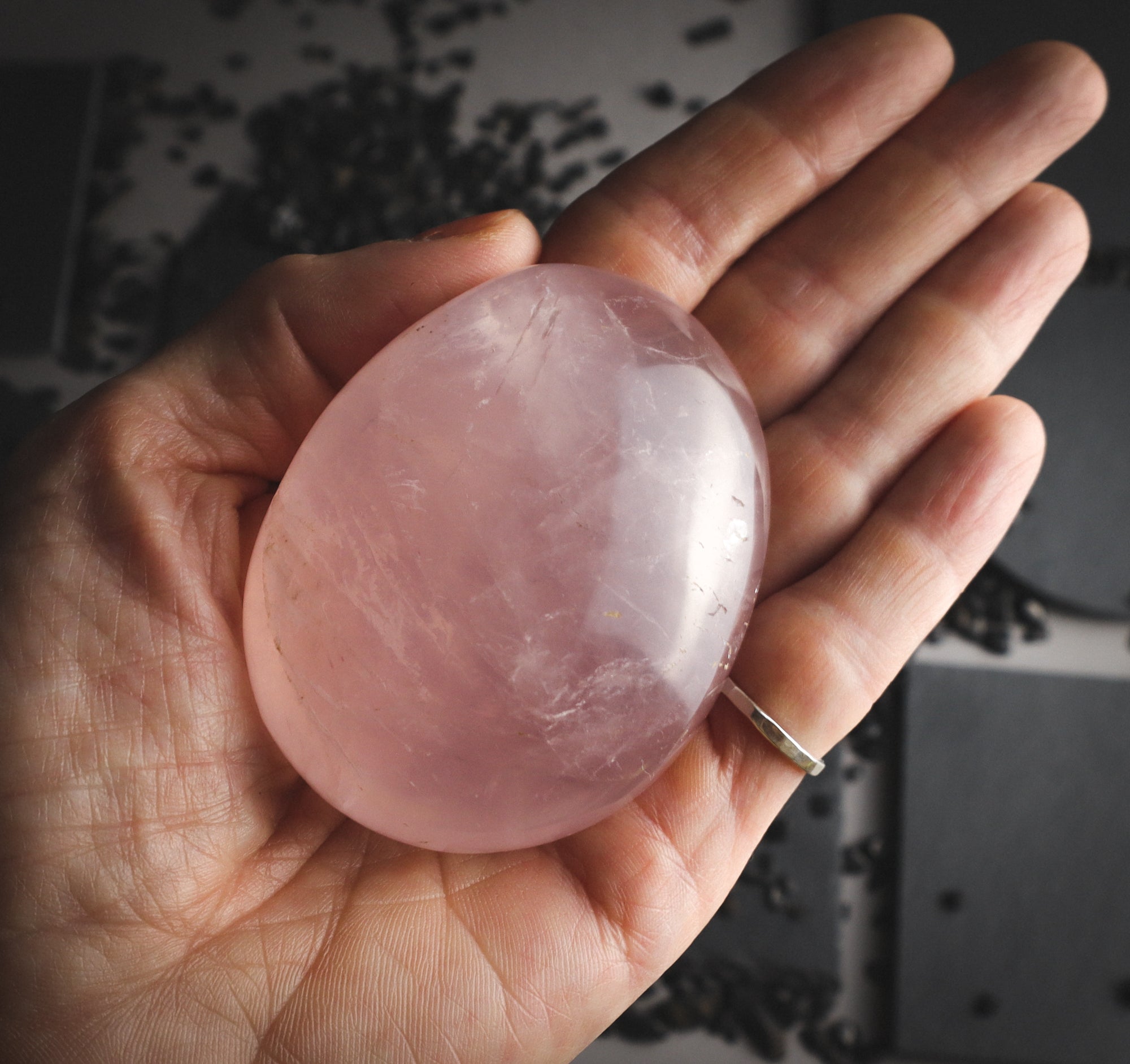 Glossy rose quartz with reflection in a hand.