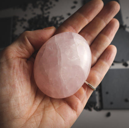 Pink and white mineral in a hand for comparison.