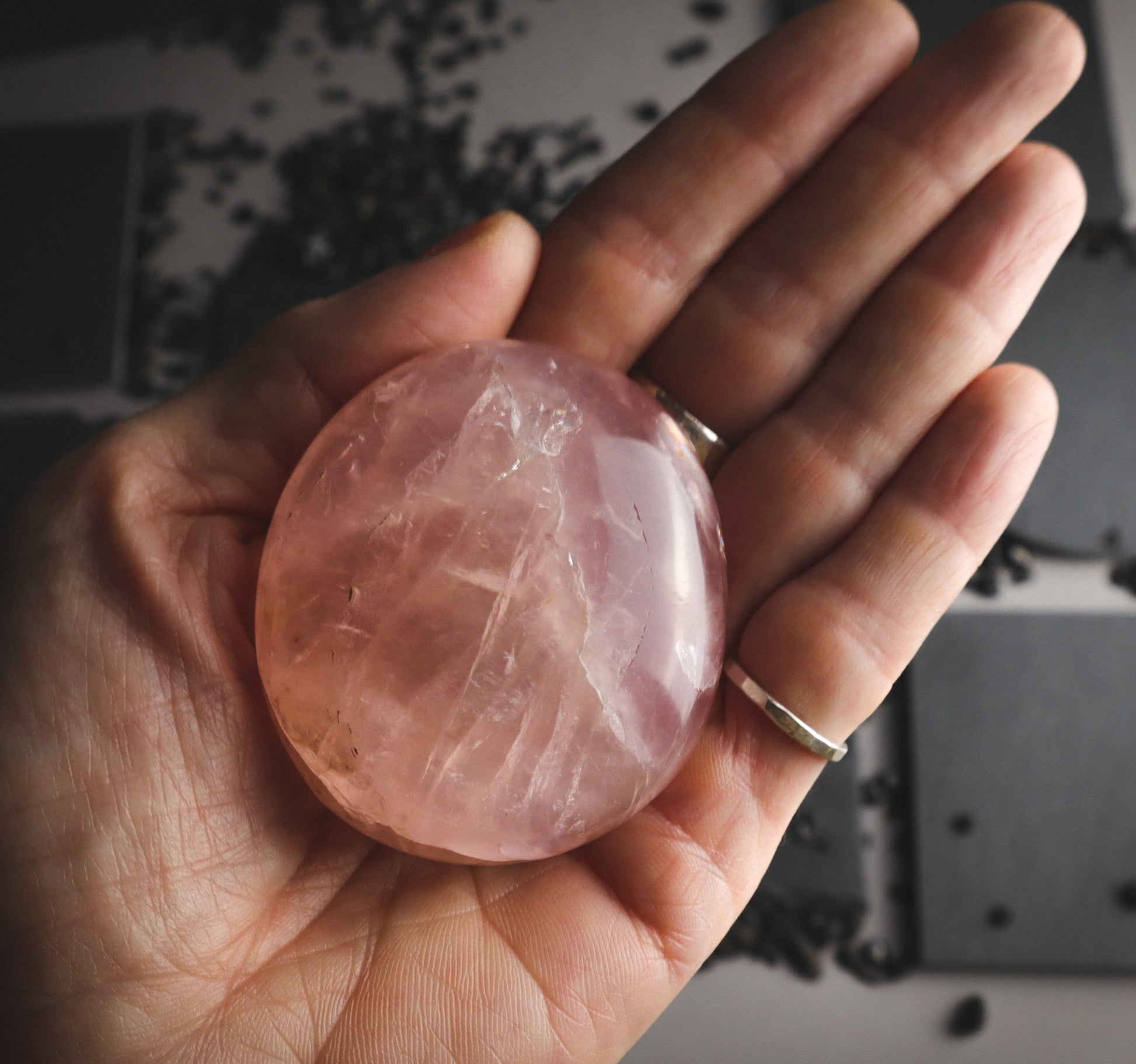 Rose reflective mineral with cracks in a hand.