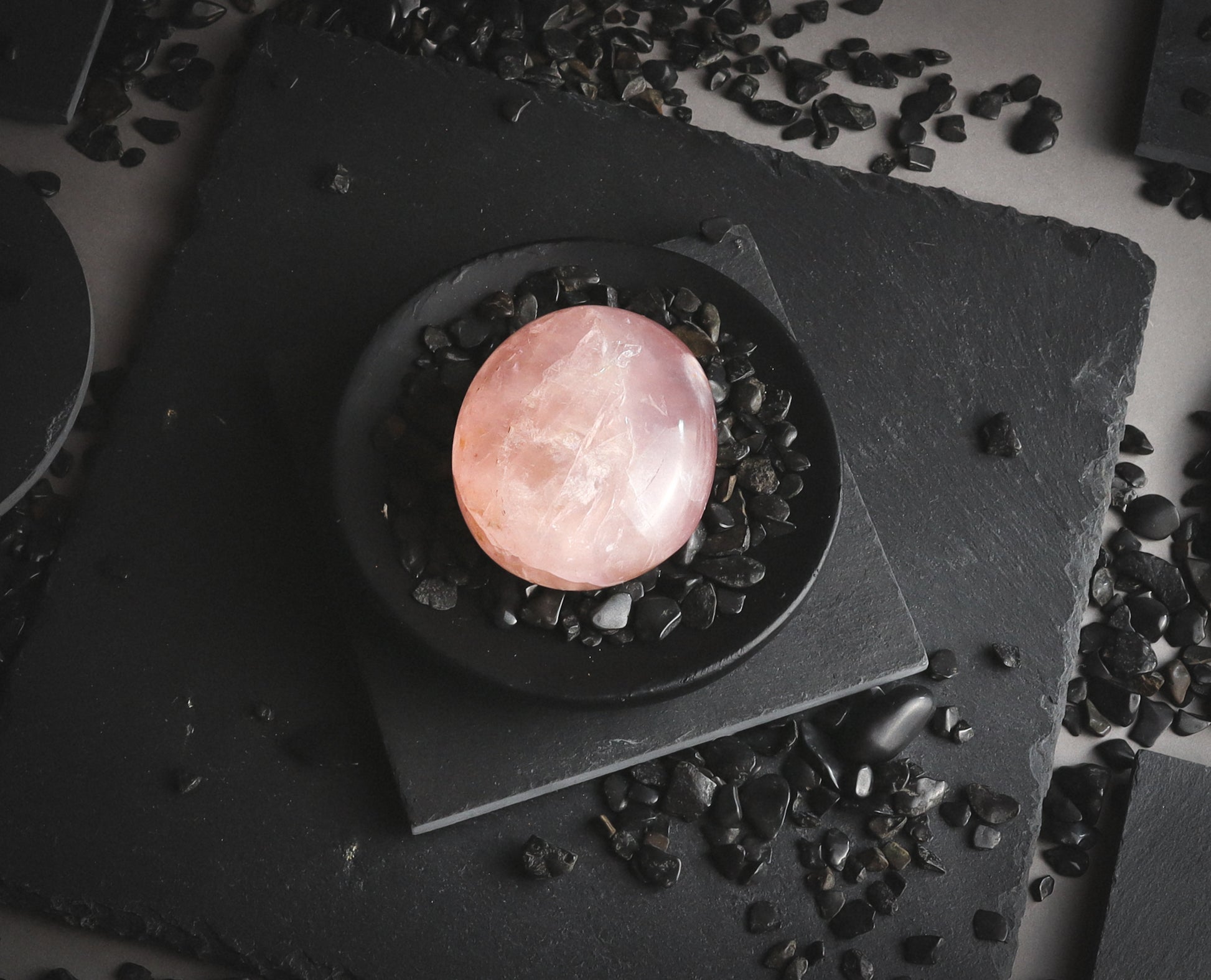 Pink round stone on a dark plate.