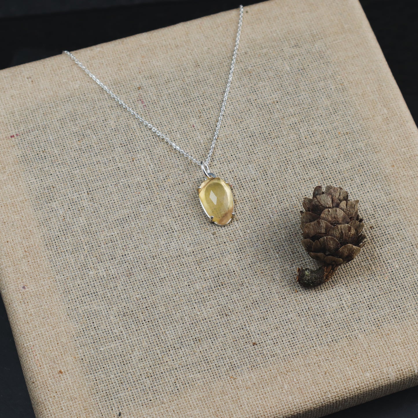 Homemade silver pendant with a yellow crystal.