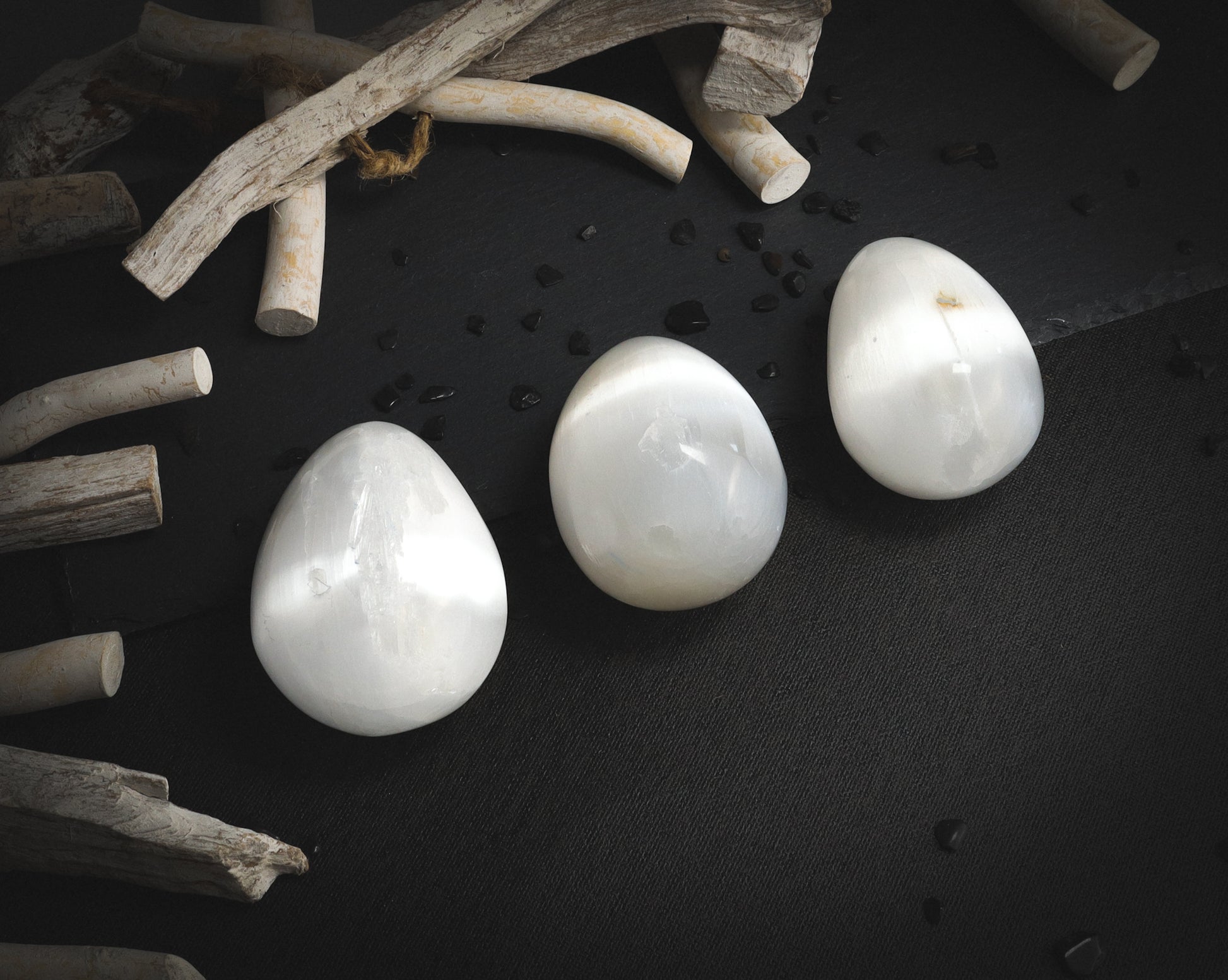 Polished selenite eggs on a dark background.