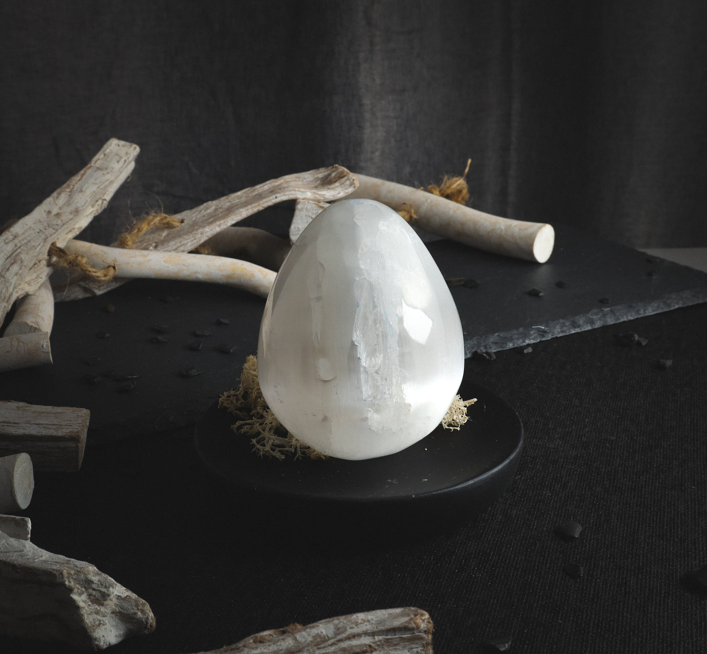 Polished selenite egg with reflection.