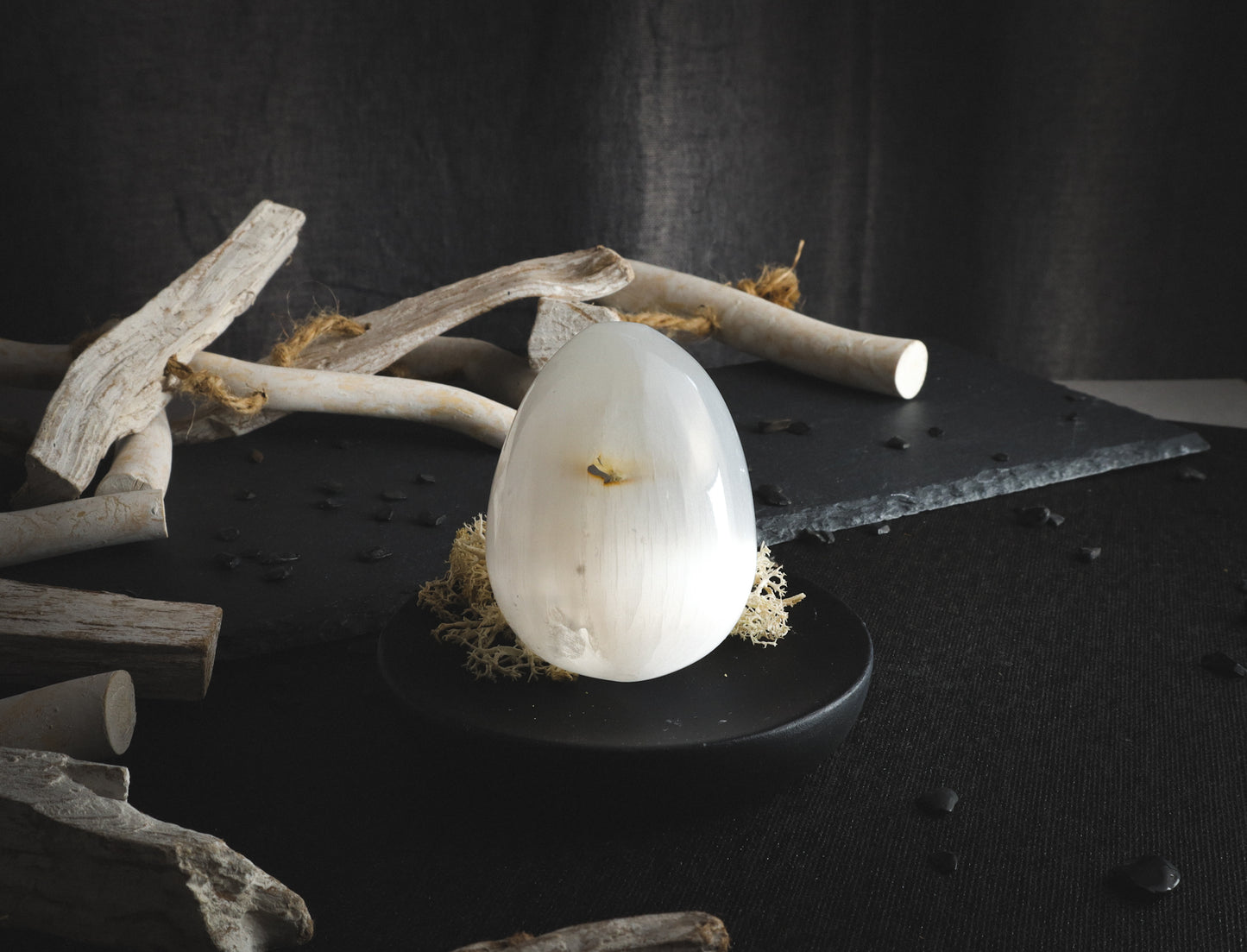 Selenite egg on a pedestal with imperfection.