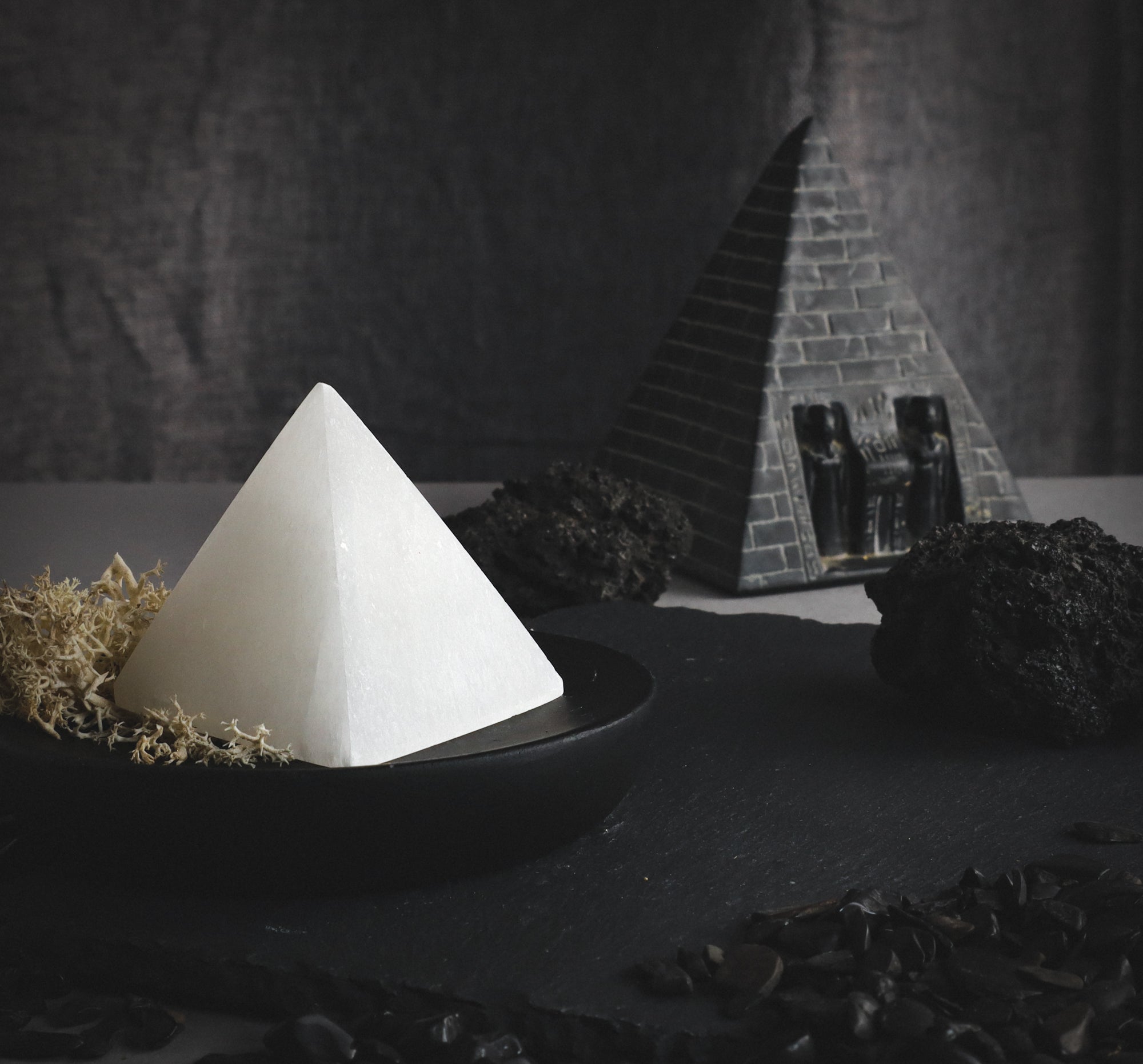 Selenite pyramide against a dark background.