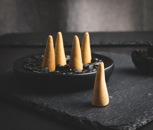 Nag champa incense cones on a dark background.