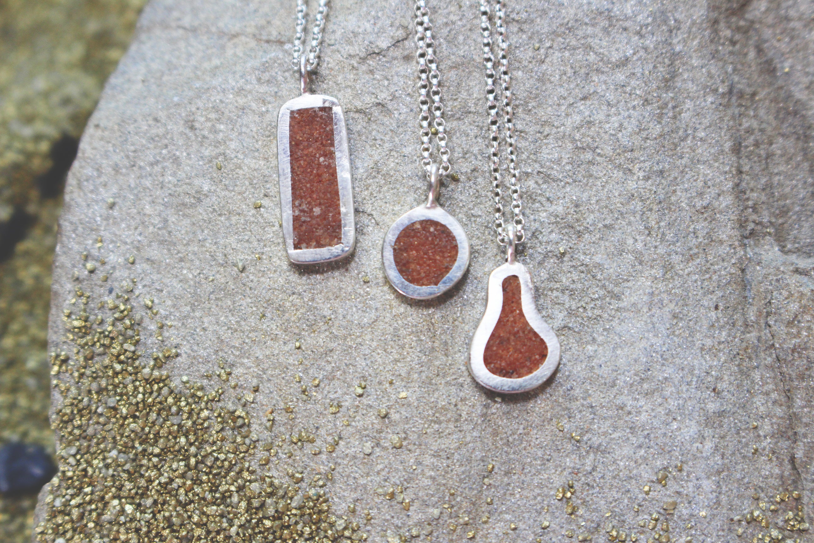 three silver pendants with Sahara sand inlay