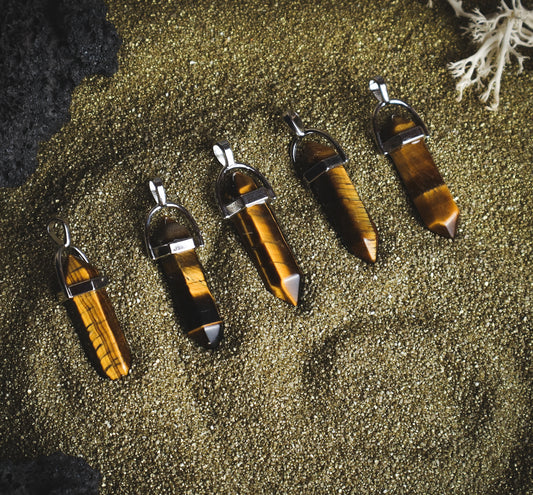 Mineral pendants against the sand.