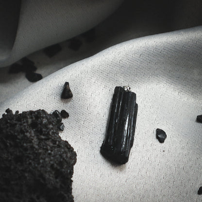 Pendant with a raw black mineral.